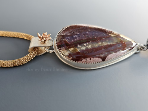 Fancy jasper cabochon has shades of burgundy, rose and pink with a splash of gold in this artisan pendant.