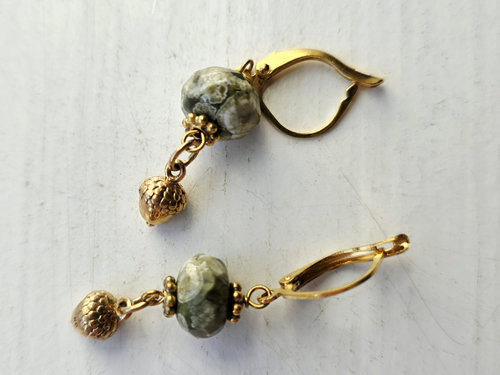 Green and gold earrings feature rhyolite and acorn drops