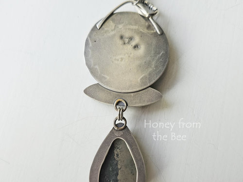 Photo shows back of artisan pendant