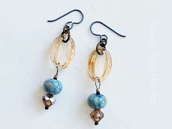 Artisan earrings feature lampwork and crystals in sky blue and champagne
