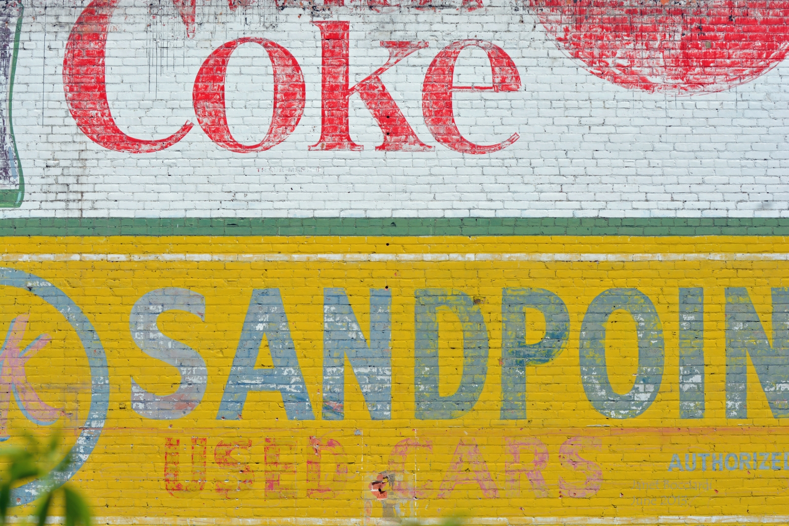 Old painted Coke sign on side of building