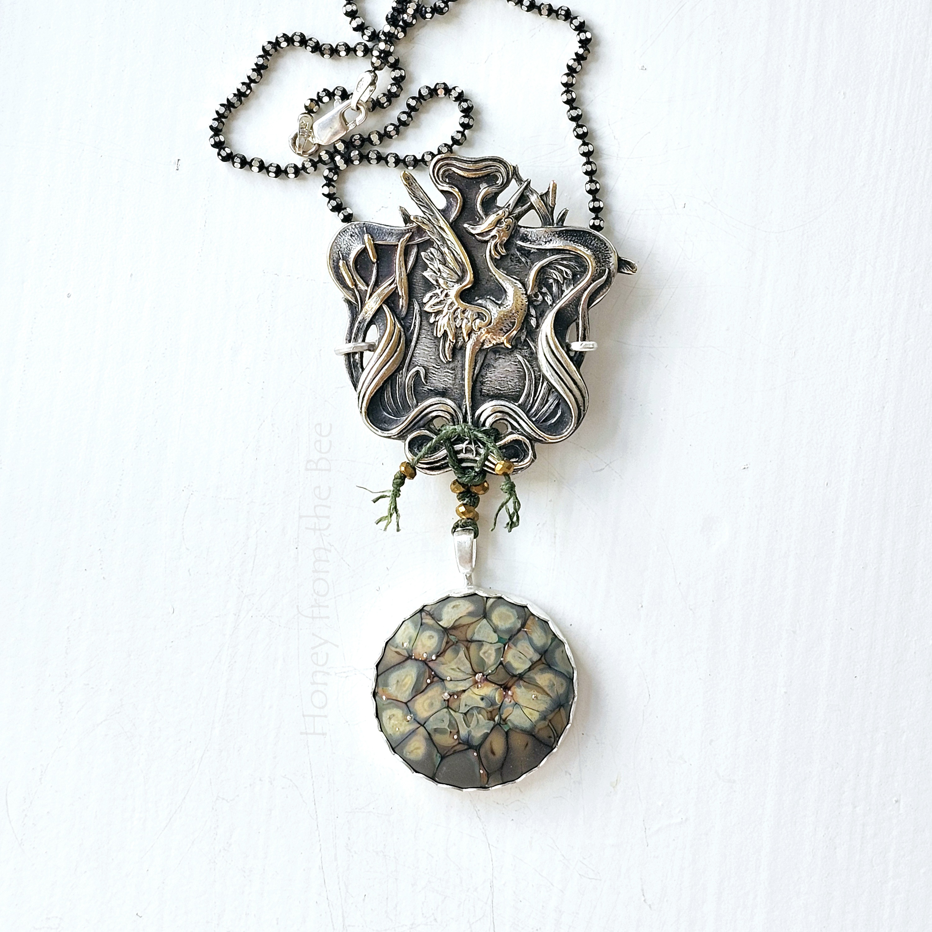 Art Pendant featuring cranes and art glass in green