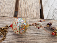 Hollow artisan lampwork pendant in orange, tan and green