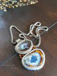 Boulder Opal pendant captured by seed beads and coordinated with artist ceramic cabochon and pearls