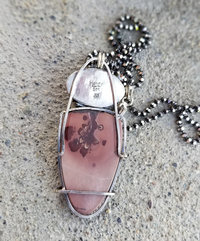 Back of Apache sage pendant shows wire frame on the apache sage cabochon and smooth sterling silver oval behind the cast pinecone.