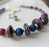 Blue and red necklace with disc lampwork and faceted gemstones