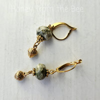 Green and gold earrings feature rhyolite and acorn drops