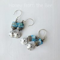 Lampwork earrings feature sand dollar charm dangles and blue and sandy lampwork
