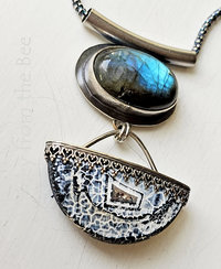 Oval labradorite cab set in sterling silver with swinging acid etched agate cabochon