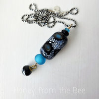 Blue and black lampwork pendant with antique button dangle
