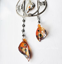 Orange butterfly wing dangles on this statement necklace.