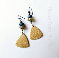 Casual earrings in blue and yellow feature lampwork and fossilized coral agate