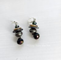 Iridescent earrings feature lampwork, crystal and antique button in shades of purple, yellow, blue, and teal