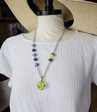 Blue and white artisan necklace with pops of yellow on model