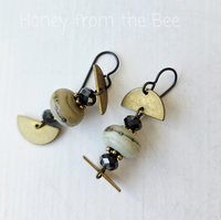 Gold and white earrings with black accents