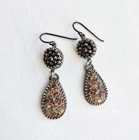 Fossilized Dinosaur bone cabochon teardrop dangles from antique steel cut button in this pair of one of a kind earrings