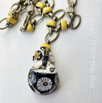 Daisy necklace features lampwork in black, white and yellow