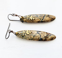 Nature inspired artisan earrings with a tan stone with dark teal lines and a brass Tamarack branch charm.