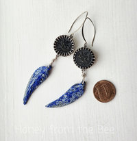 Blue and silver earrings feature lapis lazuli feather dangles and antique glass button