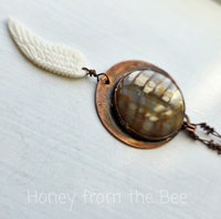 Angel wing pendant with petrified wood set in copper