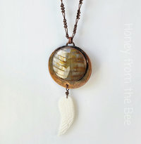 Copper pendant with petrified wood and angel wing