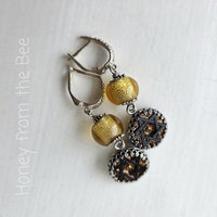 Antique black glass button earrings with star image and gold dichroic bead
