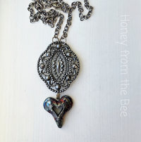 Gothic style necklace features heart in raku
