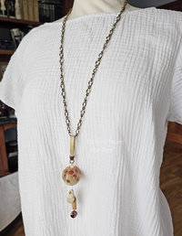 Beach tunic length pendant on model.