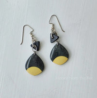 Black and cream earrings feature mixed media