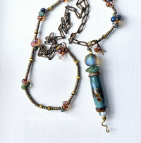 Tunic length art necklace features lampwork in shades of blue green and amber