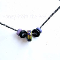 Purple and green lampwork hung from a 20 inch sterling silver chain