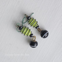 Light green and black earrings feature lampwork and crystals