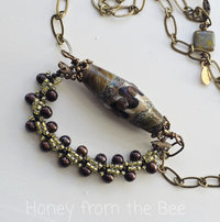 Brown beaded necklace features lampwork focal and brown pearls