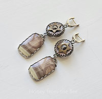 One of a kind earrings feature antique buttons with star motif and imperial jasper with moon motif