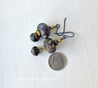 Artisan earrings feature raku lampwork and antique button drops