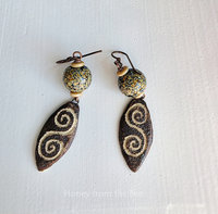 Earthtone earrings feature lampwork in brown, cream and black with a ceramic drop that has a swirl on it