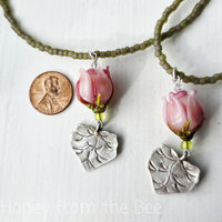 Young woman necklace features pink rosebud and silver leaf
