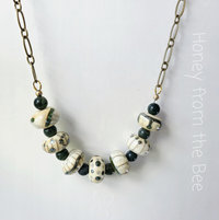 Green and white necklace features lampwork and moss agate