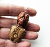 Carved wood owl sitting atop a gemstone that looks like wood - artisan pendant