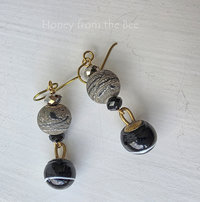 Black and gold artisan earrings feature lampwork and antique buttons