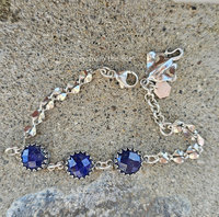Silver bracelet with navy blue gemstones and a stingray charm.