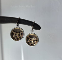 Antique button earrings feature roses on a trellis in brass and are set in sterling silver