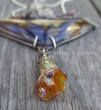 Close up of lampwork flower dangle with crystal inside