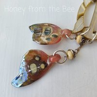 Pink and cream pendant is nature inspired with butterfly wings in glass