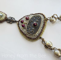 Bead embroidered statement necklace in brass, white, green and red