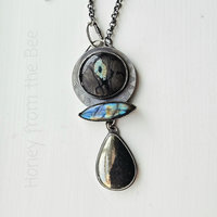 Statement necklace features silver, labradorite, apache gold, and glass art cab
