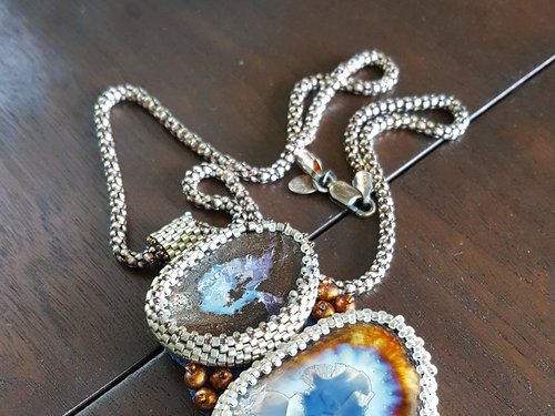 Boulder Opal pendant captured by seed beads and coordinated with artist ceramic cabochon and pearls