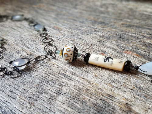 Long necklace in carved bone and chalcedony