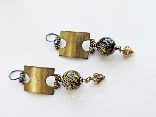 Earthtones and brass highlight this pair of artisan earrings.