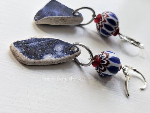 Cobalt blue sea pottery dangle from vintage African trade beads in red white and blue in this pair of casual earrings.